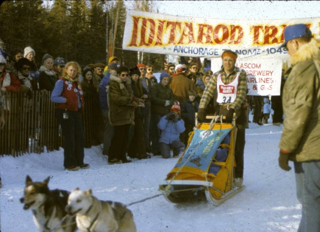 Juneaus Bruce Denton at the 1980 ceremonial start of the Iditarod Sled Dog Race beneath the familiar banner in Anchorage. All racers transition with their teams to Knik, north of the city, to load sleds and begin the official start of their 1,049-mile race to Nome. Denton finished 10th and 17th among teams of about 70 entrants in different years. (Photo courtesy Bruce Denton)