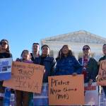 Demonstrators stand outside of the U.S. Supreme Court, as the court hears arguments over the Indian Child Welfare Act, Nov. 9, 2022, in Washington. The Supreme Court on Thursday preserved the 1978 Indian Child Welfare Act, which gives preference to Native American families in foster care and adoption proceedings of Native children, rejecting a broad attack from Republican-led states and white families who argued it is based on race. (AP Photo/Mariam Zuhaib, File)