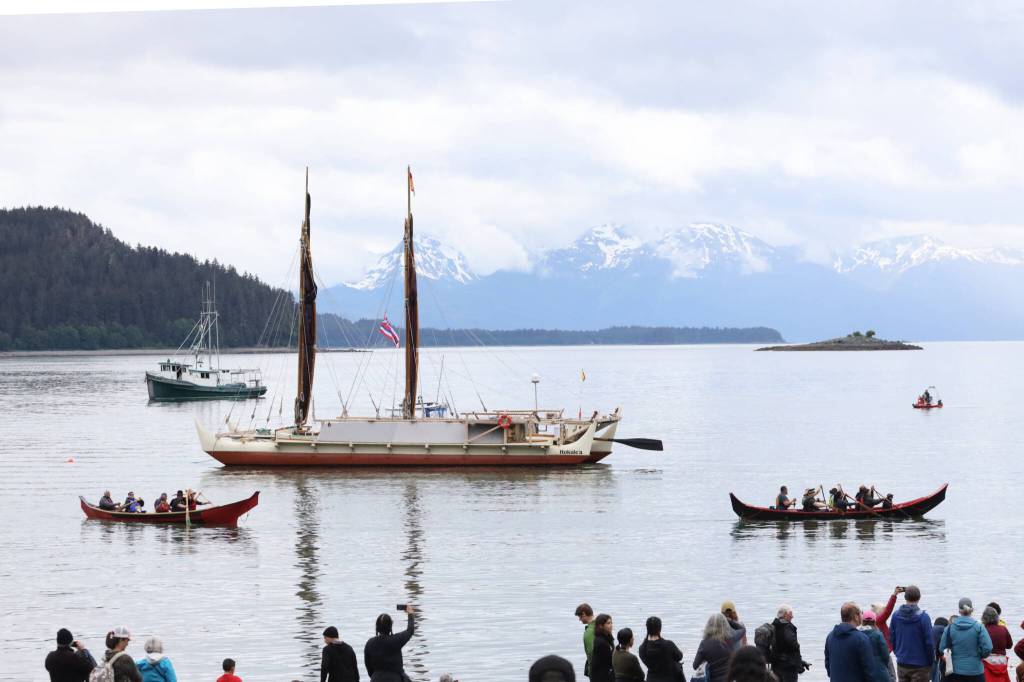 A crowd gathers at the shore of Auke Bay as the Hōkūlea, a double-hulled and wind-powered traditional Polynesian voyaging canoe, arrives in Juneau on Saturday afternoon for a welcoming ceremony. (Clarise Larson / Juneau Empire)