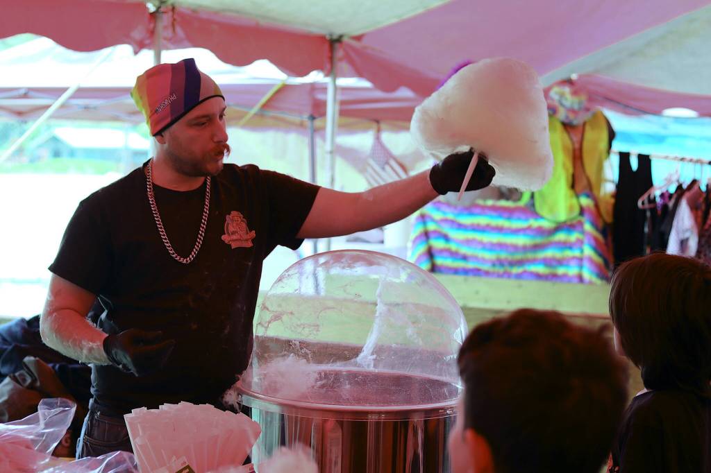 Ivan Adams, owner of Twhrly Whrliy (yes, thats how its spelled), offers fresh-spun cotton candy to a customer in the food and exhibitor tent during Juneau Gold Rush Days on Saturday. (Mark Sabbatini / Juneau Empire)