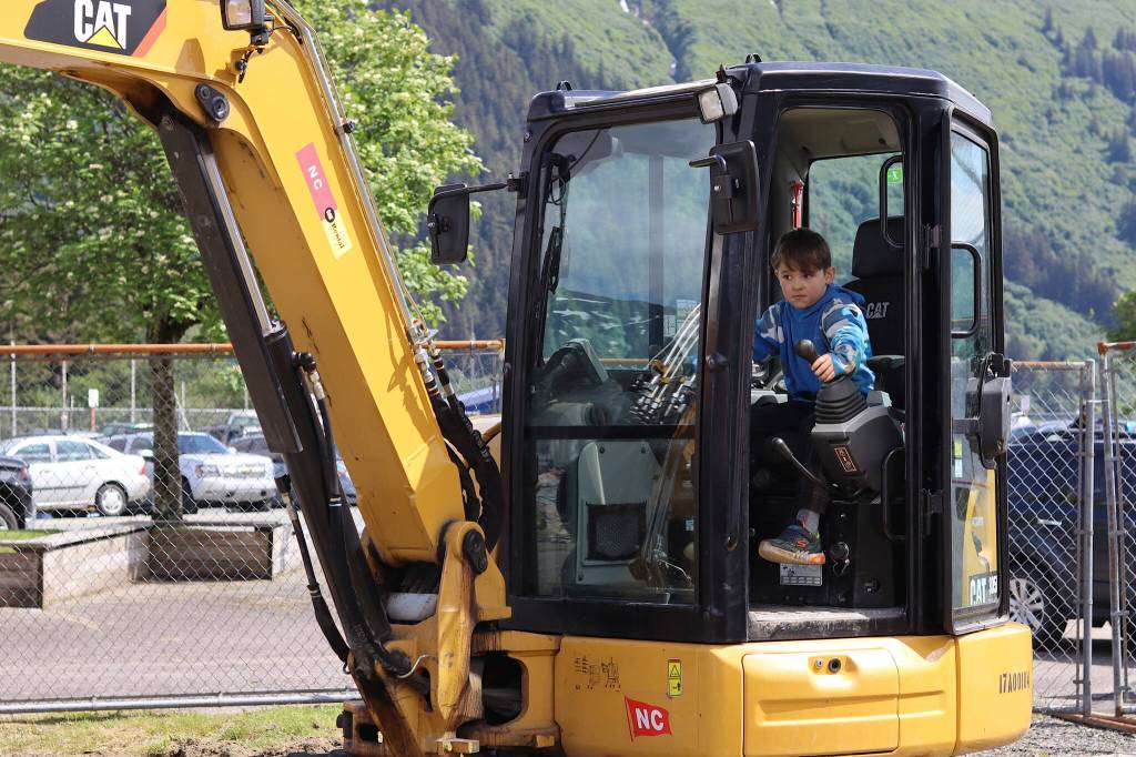 James Whistler, 8, operates a mini excavator during Gold Rush Days on Saturday. People young and old were offered a chance to place tires around traffic cones and other challenges after getting a brief introduction to the excavator. (Mark Sabbatini / Juneau Empire)