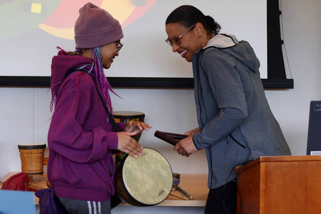 Cagney Davis, left, and her mother, Suella, play some of the percussion instruments brought to a Juneteenth celebration Saturday at the Mendenhall Valley Public Library. (Mark Sabbatini / Juneau Empire)