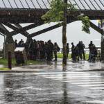 Tourists take shelter at Marine Park during a heavy rain shower on Aug. 14, 2017. (Michael Penn | Juneau Empire File)