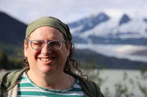 Emily Mesch, president of Southeast Alaska LGBTQ+ Alliance, smiles for a photo near the Mendenhall Glacier Thursday evening. SEAGLA is a Juneau-based nonprofit that works to provide a supporting social network for gay, lesbian, bisexual, transgender, and queer people in Southeast Alaska. (Clarise Larson / Juneau Empire)