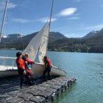 From left to right, Kaia Mangaccat, 13, Lua Mangaccat, 15, Sigrid Eller, 13, and Adrian Whitney, 19, pull a boat out of the water after a sailing lesson in Gastineau Channel this week. (Therese Pokorney / Juneau Empire)