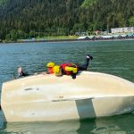 Lauren Stichert, 16, and Angus Andrews, 14, climb aboard a capsized sailboat during a sailing lesson this week in Gastineau Channel. (Photo by Adrian Whitney)