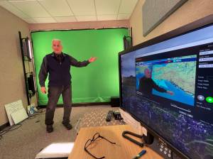 In this June 21 photo, meteorologist David Percy films the daily Alaska Weather program in a makeshift studio at the National Weather Service office in Anchorage. The Alaska Weather program she oversees, the only weather show produced by the National Weather Service, will have its last on-air broadcast Friday after Alaska Public Media dropped distribution, forcing it to YouTube. (AP Photo/Mark Thiessen)