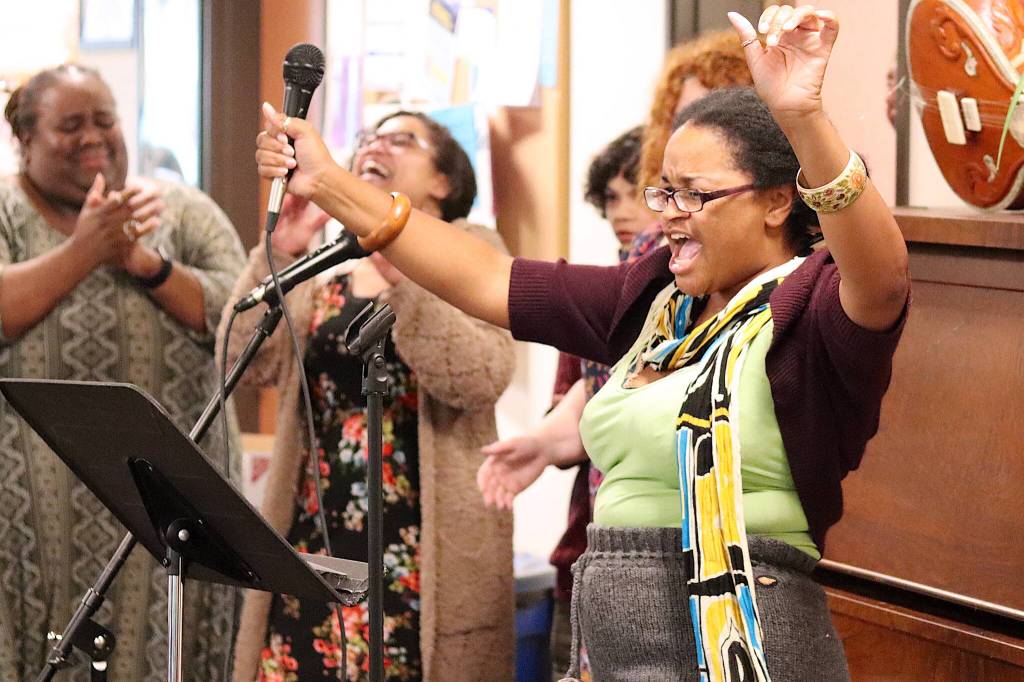 Erika Lee leads other singers in a version of Redneck Woman with adapted local lyrics during the closing song of a Neighborhood Cabaret show at the Glory Hall on Thursday evening.
