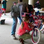 Jim Dalman and his granddaughter Devlin, 6, decorate a bicycle in the Douglas Library parking garage Saturday during the annual pre-July 4 gathering to prepare for the Children’s Parade on Independence Day. (Therese Pokorney / Juneau Empire)