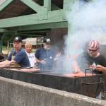Douglas firemen Rych Clime, left, beard and Ray Roberts grill burgers and hot dogs near a shelter at Sandy Beach during a community picnic Monday evening. (Therese Pokorney / Juneau Empire)
