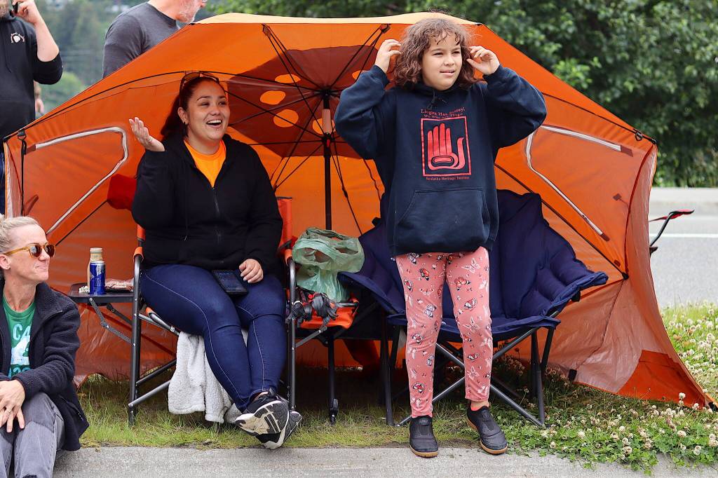 Davina Cole and her daughter, Skylar, 8, watch the Fourth of July parade from their tent-size umbrella near downtown Juneau on Tuesday. (Mark Sabbatini / Juneau Empire)