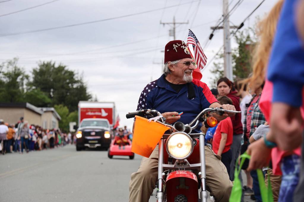 Bob Heflin, a Juneau-Douglas Shrine Club member, hands out candy on his mini motorcycle Tuesday afternoon during the annual Fourth of July parade in Douglas. (Clarise Larson / Juneau Empire)