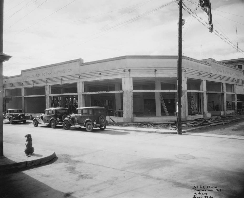 Looking into the 1930s AELP building under construction with a patient dog waiting on the corner. A copy of this photo has an honored place inside Amalga Distillery. Taken September 10, 1936 by Delano. (Photo courtesy AELP)