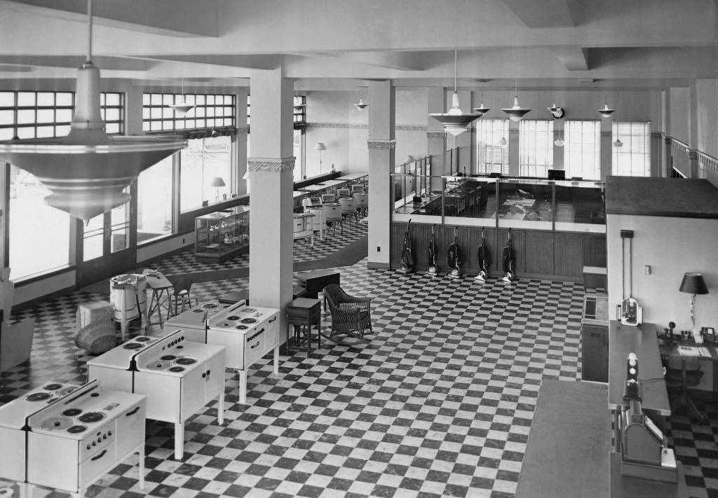 Alaska Electric Light and Power Companys 1937 showroom displays new labor-saving electric appliances such as cooking ranges, vacuum cleaners, lamps, toasters, irons, and wringer washing machines. The building is located at Second and Franklin Streets. Over the years, many different businesses have occupied the concrete building. Today, it is the home of Amalga Distillery. (Photo courtesy AELP)