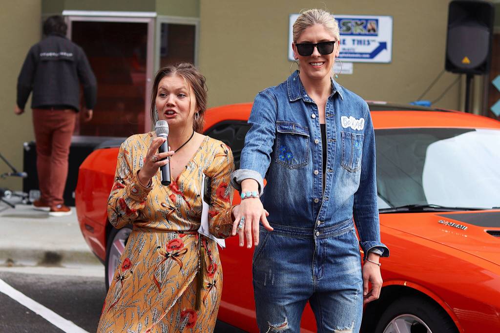 Cordova Pleasants, founder of Alaska Fashion Week and owner of Resolute Boutique in Juneau, tells a runway show audience about jewelry made and being worn by Jackie Kragel, one of the models in Saturdays show. (Mark Sabbatini / Juneau Empire)
