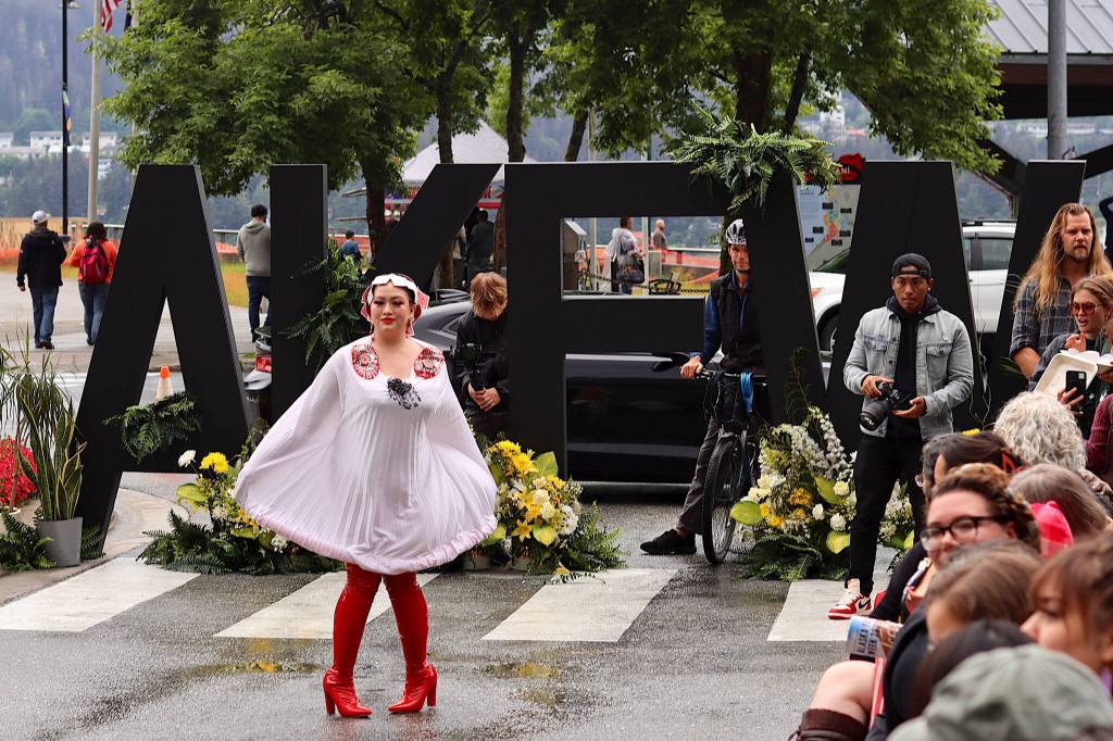 Lettering for an Alaska Fashion Week backdrop is placed on Ferry Way across from Marine Park for Saturdays outdoor runway show in downtown Juneau. The location meant a steady stream of cruise ship visitors passed by, some stopping to watch portions of the show. (Mark Sabbatini / Juneau Empire)