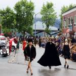 Models walk along Ferry Way in downtown Juneau during Alaska Fashion Weeks runway show Saturday afternoon. Organizers said the event would take place outside rain or shine, but a heavy downpour during the morning gradually tapered off and stopped just before the start of the show. (Mark Sabbatini / Juneau Empire)
