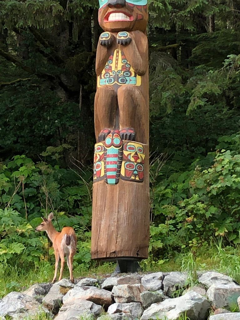 A deer wanders near the Auke Rec Totem Pole at about 15 Mile Glacier Highway on July 19. (Photo by Joe Orsi)