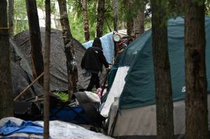 Tents fill a homeless camp near Davis Park in Mountain View on July 3 in Anchorage. An unfunded proposal by Anchorages mayor to pay for plane tickets to warmer climates for homeless people who would otherwise be forced to winter outside in the bitter cold has caused a stir in Alaskas biggest city. If the program moves forward, people can choose to relocate to the Lower 48 or somewhere else in Alaska where it might be warmer or where they have relatives. (Bill Roth / AP)
