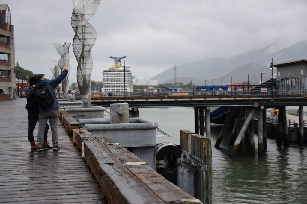 Visitors take a selfie on the downtown cruise ship docks in July. (Clarise Larson / Juneau Empire File)