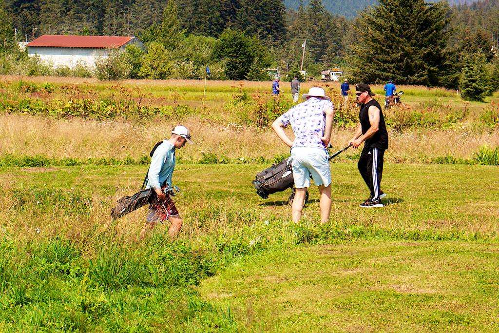 Dylan Williams (left), Matt Seymour (center) and Mark Wendling look for their balls in the rough at the seventh hole of the Annual Greater Juneau Chamber of Commerce Golf Classic on Saturday at the Mendenhall Golf Course. (Mark Sabbatini / Juneau Empire)