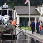 U.S. Coast Guard Chief Petty Officer Nicholas Sedberry is joined by other service members and visitors aside a 29-foot Coast Guard response boat during National Night Out events in Juneau on Tuesday. (Meredith Jordan / Juneau Empire)