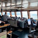 Capt. Dave Turner and Chief Mate Lucas Bevegni on the bridge of Columbia state ferry as Bevegni takes note of a whale spout more than a mile in the distance. (Meredith Jordan / Juneau Empire)