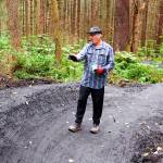 Jack Kreinheder, a board member of both the Juneau Mountain Bike Alliance and Trail Mix, explains the planning process for the turns and other features on the beginners trail at the new Thunder Mountain Bike Park on Saturday. (Mark Sabbatini / Juneau Empire)