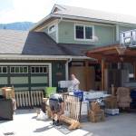 Local residents move belongings out of a home along the Mendenhall River that has about one-fourth of the structure hanging over the bank at midday Sunday, following massive erosion caused by record flooding Saturday. (Mark Sabbatini / Juneau Empire)