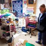 Chris Winter examines damage in the crafts room of her house on View Drive on Sunday, which was saturated by record flooding from Suicide Basin on Saturday. The flooding tore loose oil tanks and other items along the shore, contaminating the water that drenched the flooded residences. (Mark Sabbatini / Juneau Empire)