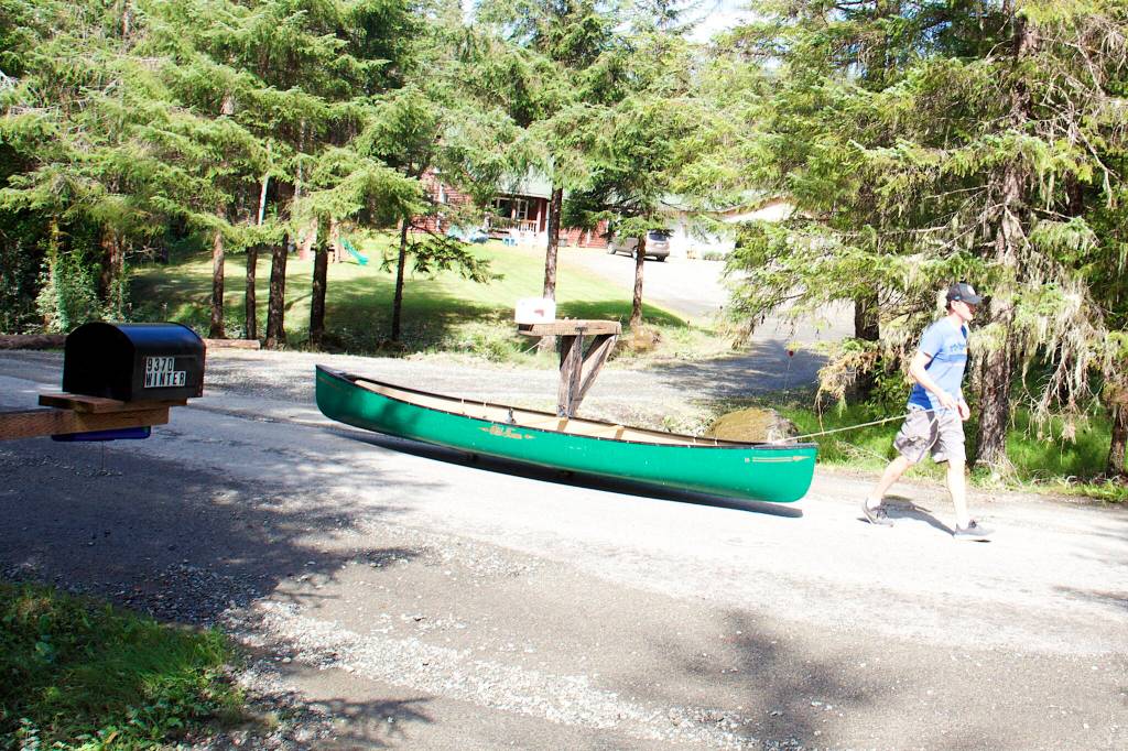A man hauls a canoe down View Drive on Sunday, a day after residents used various boats to shuttle to and from homes that were cut off from road access to the rest of Juneau by record flooding from Suicide Basin. (Mark Sabbatini / Juneau Empire)