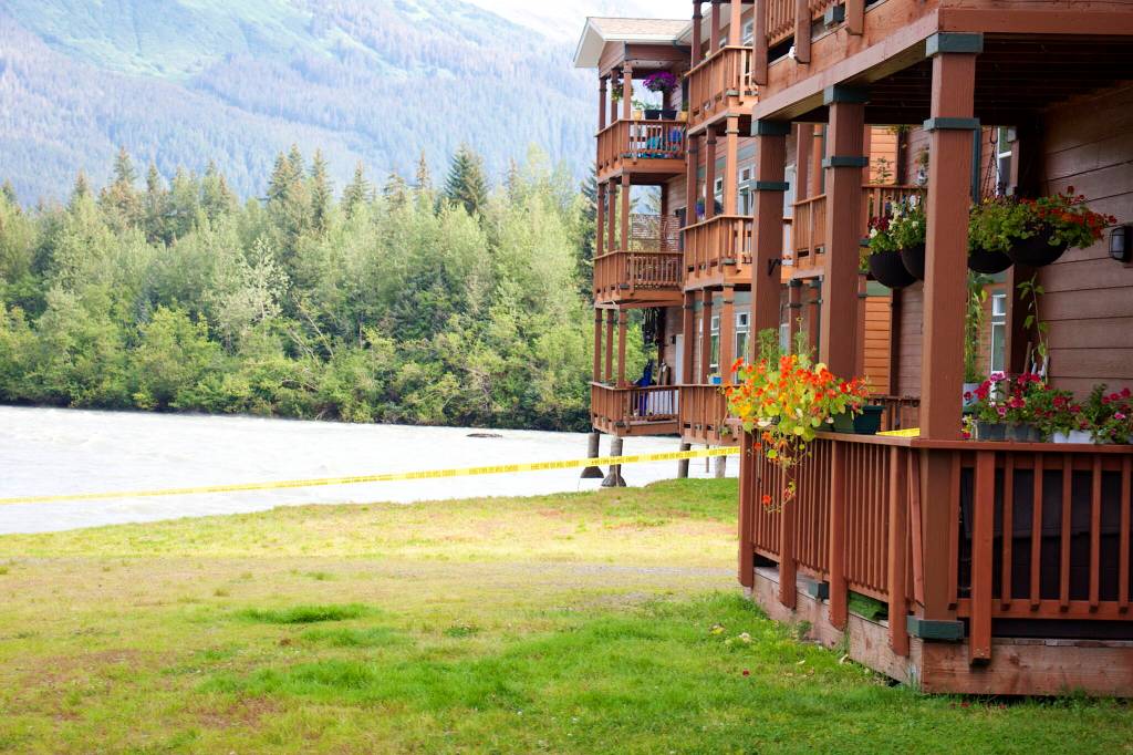 Part of a condominium complex hangs over an eroded embankment along the Mendenhall River on Sunday. Two buildings in the complex were evacuated on Saturday due to record flooding from Suicide Basin. (Mark Sabbatini / Juneau Empire)