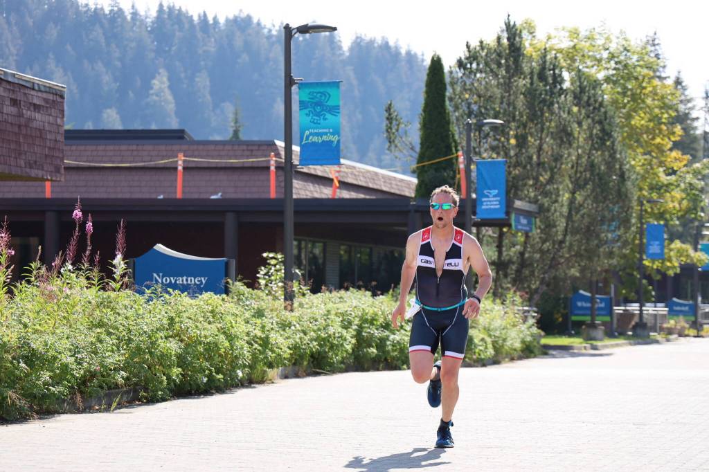 Hiram Henry races to the finish line Sunday morning as he completes the Olympic race of the Aukeman Triathlon at the University of Alaska Southeast campus. (Clarise Larson / Juneau Empire)