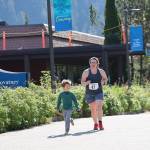 Erin Heard heads to the finish line with the help of her son Parker, 5, as she completes the sprint race of the Aukeman Triathlon at the University of Alaska Southeast campus on Sunday. (Clarise Larson / Juneau Empire)