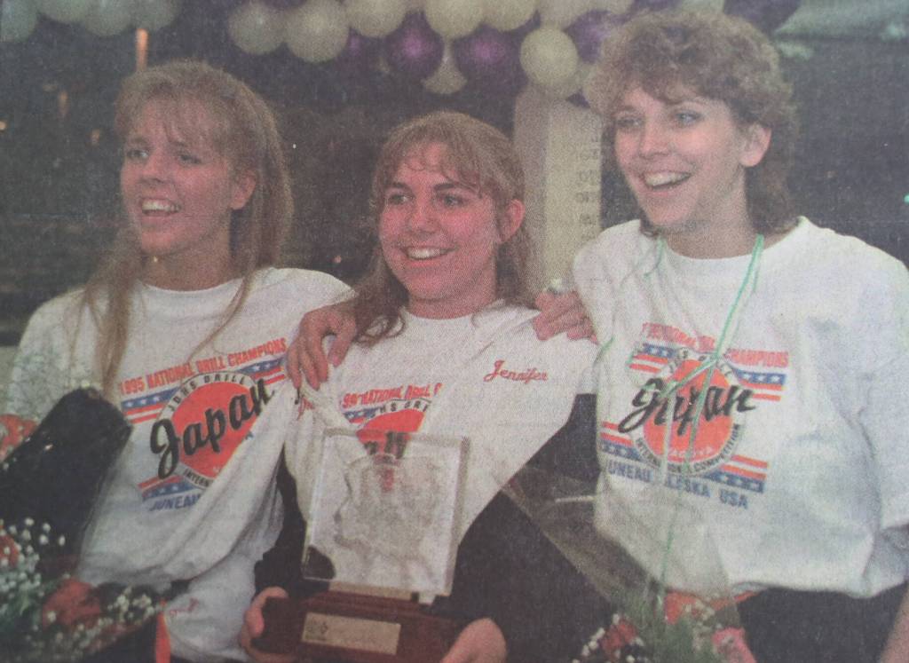 Assistant drill team coach Evonne Noonan, left, drill team captain Jennifer Fredrick and drill team coach Leslie Dahl pose photographs after arriving at the airport on Tuesday, Aug. 9, 1995. The drill team was greeted by a crowd of about 400 people. (Brian Wallace / Juneau Empire Archives)