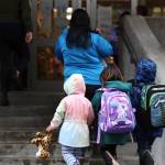Three students hold hands as they walk up the stairs to the entrance of Sayéik: Gastineau Community School for the first day of the 2023-2024 school year Tuesday morning. (Clarise Larson / Juneau Empire)
