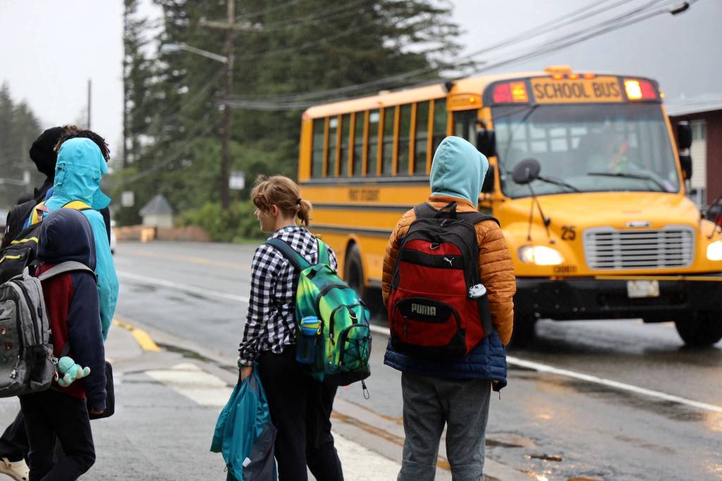 Students await their bus on Douglas Highway Tuesday morning for the first day of the 2023-2024 school year. (Clarise Larson / Juneau Empire)