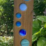 Circular shades of blue wend their way down a wooden post at the Arboretum seen on Aug. 5. (Photo by Denise Carroll)