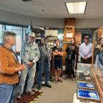 Visitors, some waiting to board the Columbia state ferry, look at a historic display at the ferry terminal in Bellingham, Washington, in July. (Meredith Jordan / Juneau Empire)