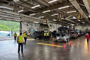 Workers load cars aboard the Columbia ferry during a stop in mid-July. (Meredith Jordan / Juneau Empire)