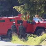 Officials stand nearby the Juneau Police Departments new armored security that was parked outside a residence where a man was later arrested in connection with a fatal shooting in July. (Clarise Larson / Juneau Empire File)