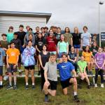 The Thunder Mountain High School cross-country team pose for a photo before their practice began outside of the high school Thursday evening. (Clarise Larson / Juneau Empire)