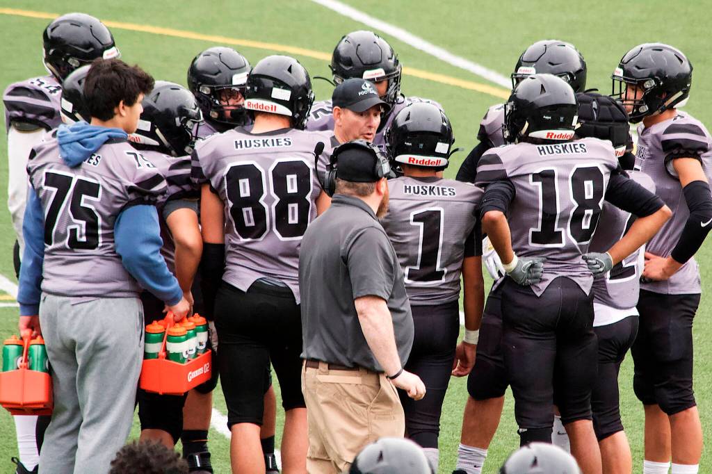 Juneau Huskies Head Coach Rich Sjoroos huddles with his players during a timeout on a fourth-and 9 at the Dimond 49 with 2:24 remaining the fourth quarter and his team trailing 40-33. Juneau was stopped for no gain on the play and Dimond was able to win the game by running out the clock. (Mark Sabbatini / Juneau Empire)