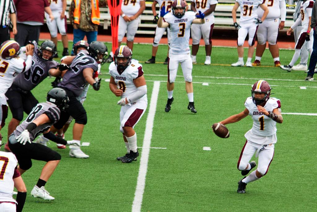 Dimond High School sophomore quarterback Cayden Pili scrambles as he looks to throw against the Juneau Huskies on Saturday at Adair-Kennedy Field. (Mark Sabbatini / Juneau Empire)