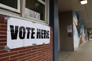 A vote here sign hangs duct taped outside of City Hall in October 2022. (Clarise Larson / Juneau Empire File)