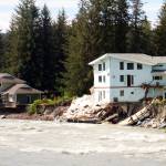 Homes along the Mendenhall River damaged by record flooding on Aug. 5 are seen hanging over an eroded embankment a day later. The flood has been declared a state disaster and officials with the Federal Emergency Management Agency arrived in Juneau on Wednesday to assess if federal disaster assistance is warranted. (Mark Sabbatini / Juneau Empire File)