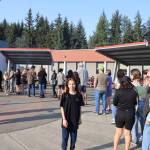 Rosemarie Becker looks toward the parking lot during Floyd Dryden Middle Schools 50th anniversary celebration Wednesday. Her father, Ed Becker, looks on as they wait in the hot dog line. (Meredith Jordan / Juneau Empire)