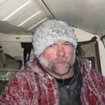 Volcano researcher John Paskievitch sits down coated in ice after three hours of creating and securing anchor points to tie off a Jet Ranger helicopter stranded by ice on the summit of Mount Mageik in the Valley of 10,000 Smokes. (Photo by Taryn Lopez)