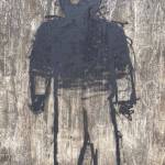 A hollow-eyed stranger watches passersby from the downtown bridge on Aug. 13. (Photo by Denise Carroll)