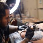 Kiko Valladolid, an artist originally from Kodiak, tattoos a spaceship on Juneau resident Tara Hansen's “galaxy leg" Thursday afternoon at Elizabeth Peratrovich Hall during the Ink Masters Tattoo Show. (Clarise Larson / Juneau Empire)